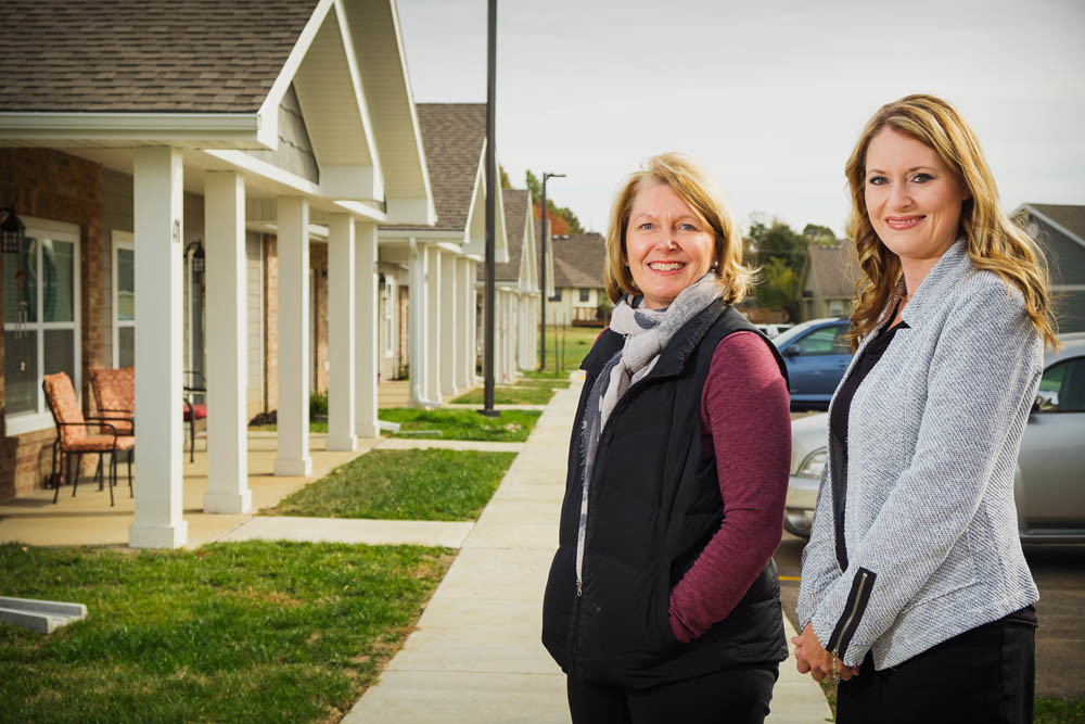HOUSING GURUS: Housing Plus co-owners Debbie Shantz Hart, left, and Becky Selle stand in front of their recently completed McClernon Villas.