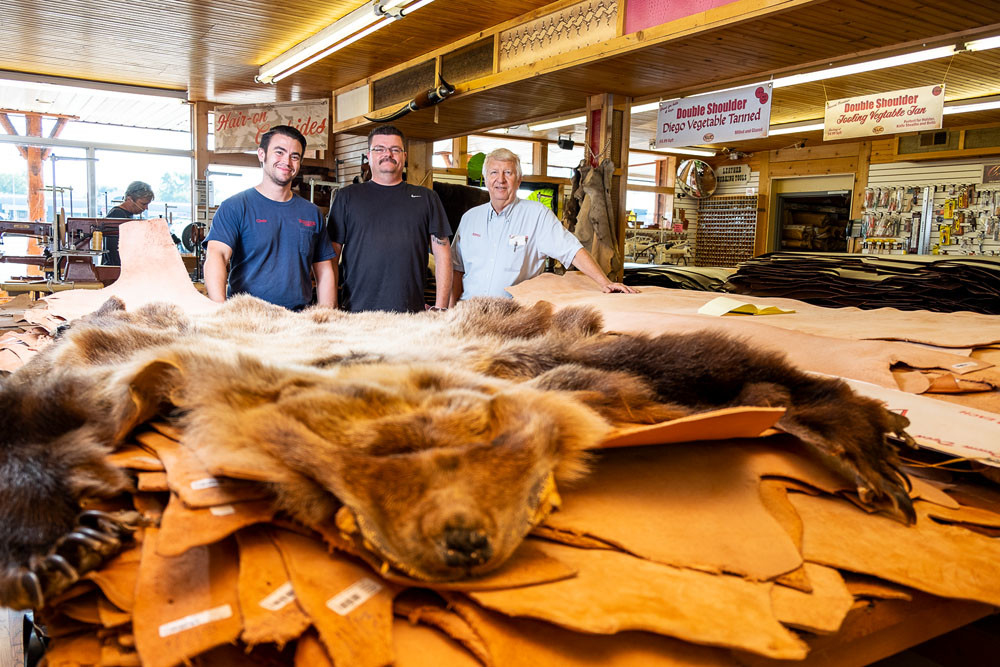 TOUGH CANVAS: Piles of leather several feet tall are a standard sight at Springfield Leather Co., run by Assistant Manager Chris Costa, far left, General Manager Rusty Darnell and owner Kevin Hopkins.