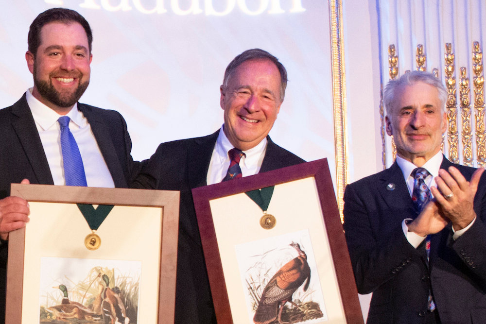 Johnny Morris, center, accepts the Audubon Medal with his son John Paul, left, and National Audubon Society CEO David Yarnold, right.