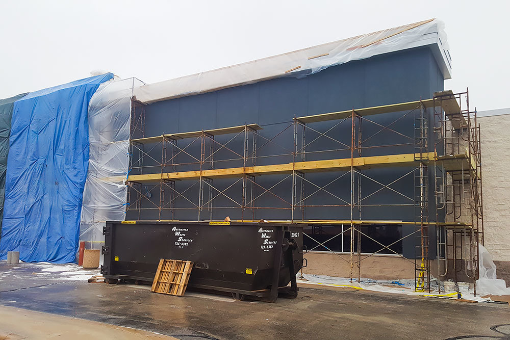The exterior of the former Toys R Us building is covered by scaffolding and tarps on Thursday.