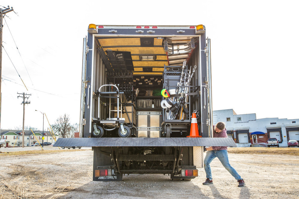 A lift gate lowers to allow users to roll out equipment.