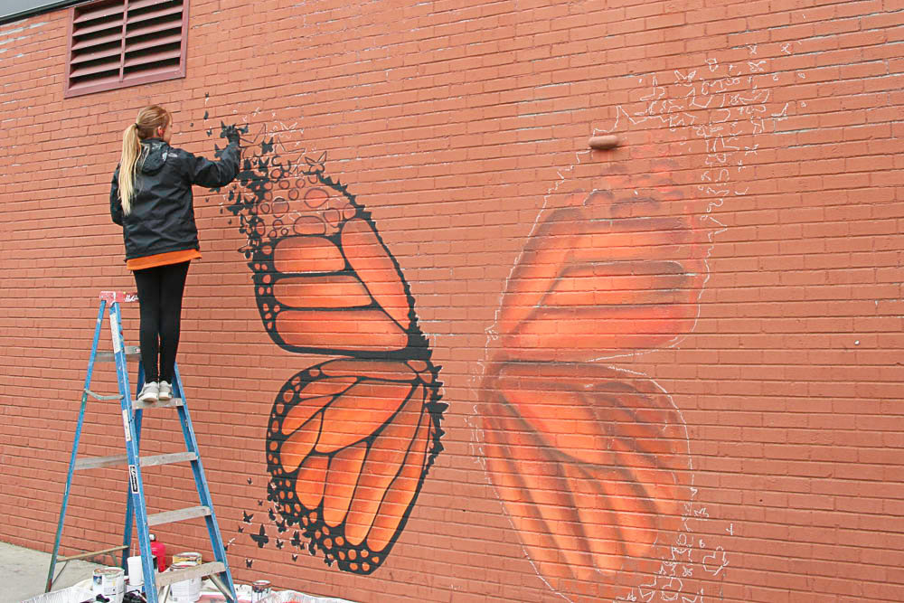 Springfield artist Andrea Ehrhardt on Thursday works on a replacement mural for her street art that was removed across the road.