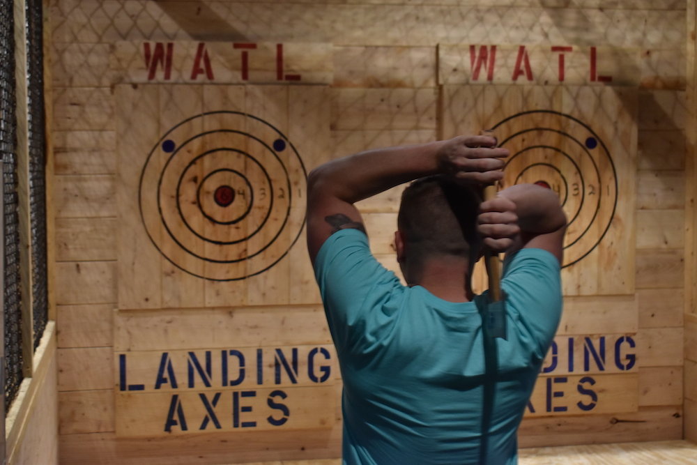 A man throws an axe at the recently opened attraction.