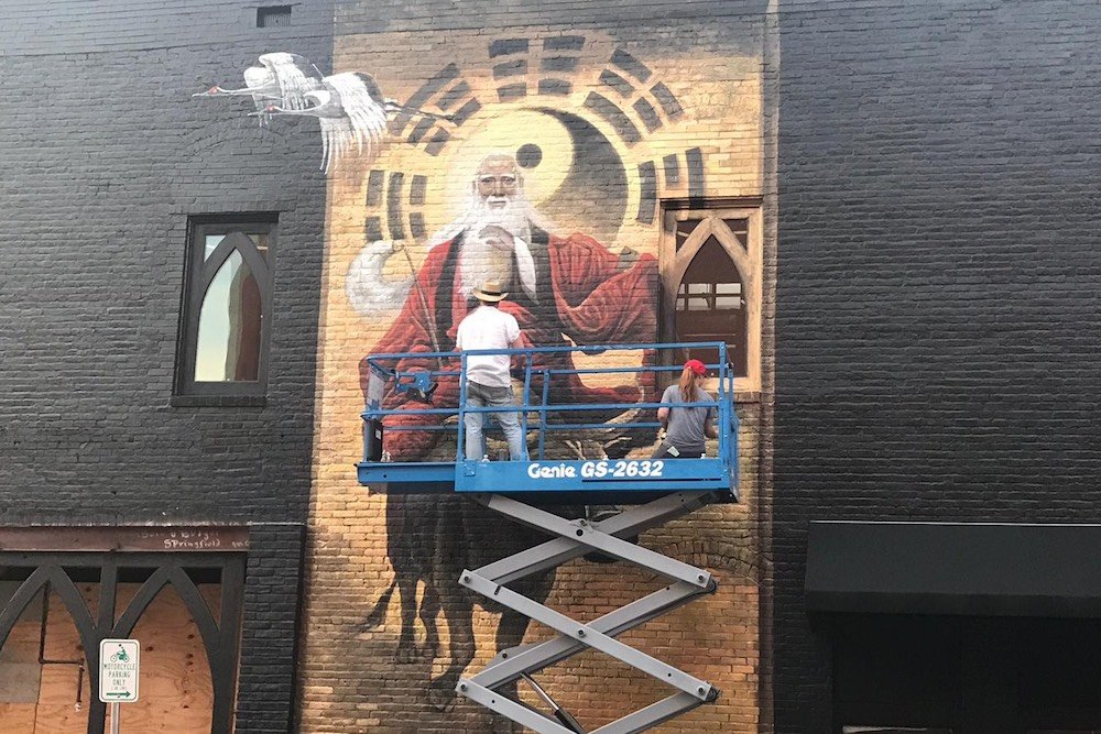Artist Brad Noble on June 21 works on a new mural depicting ancient Chinese philosopher Lao Tzu.