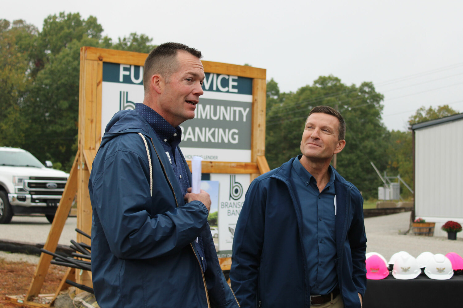 Bank officers Eric Simkins, left, and Bill Jones address the crowd in Branson West.